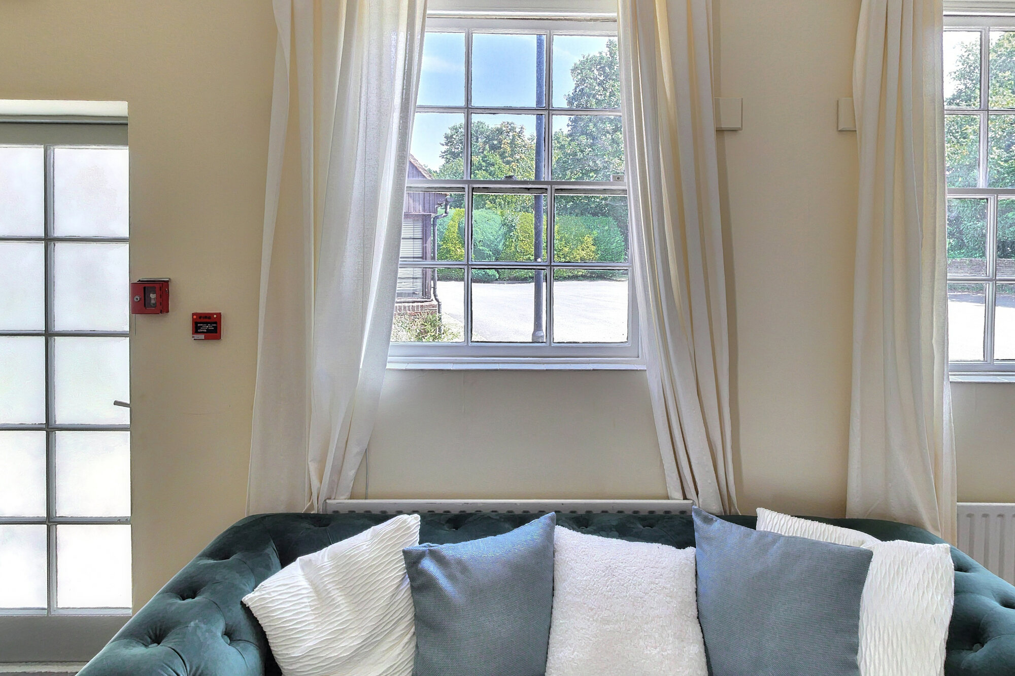 The Bridal Suite, a light dressing room with a sofa beneath tall curtained windows