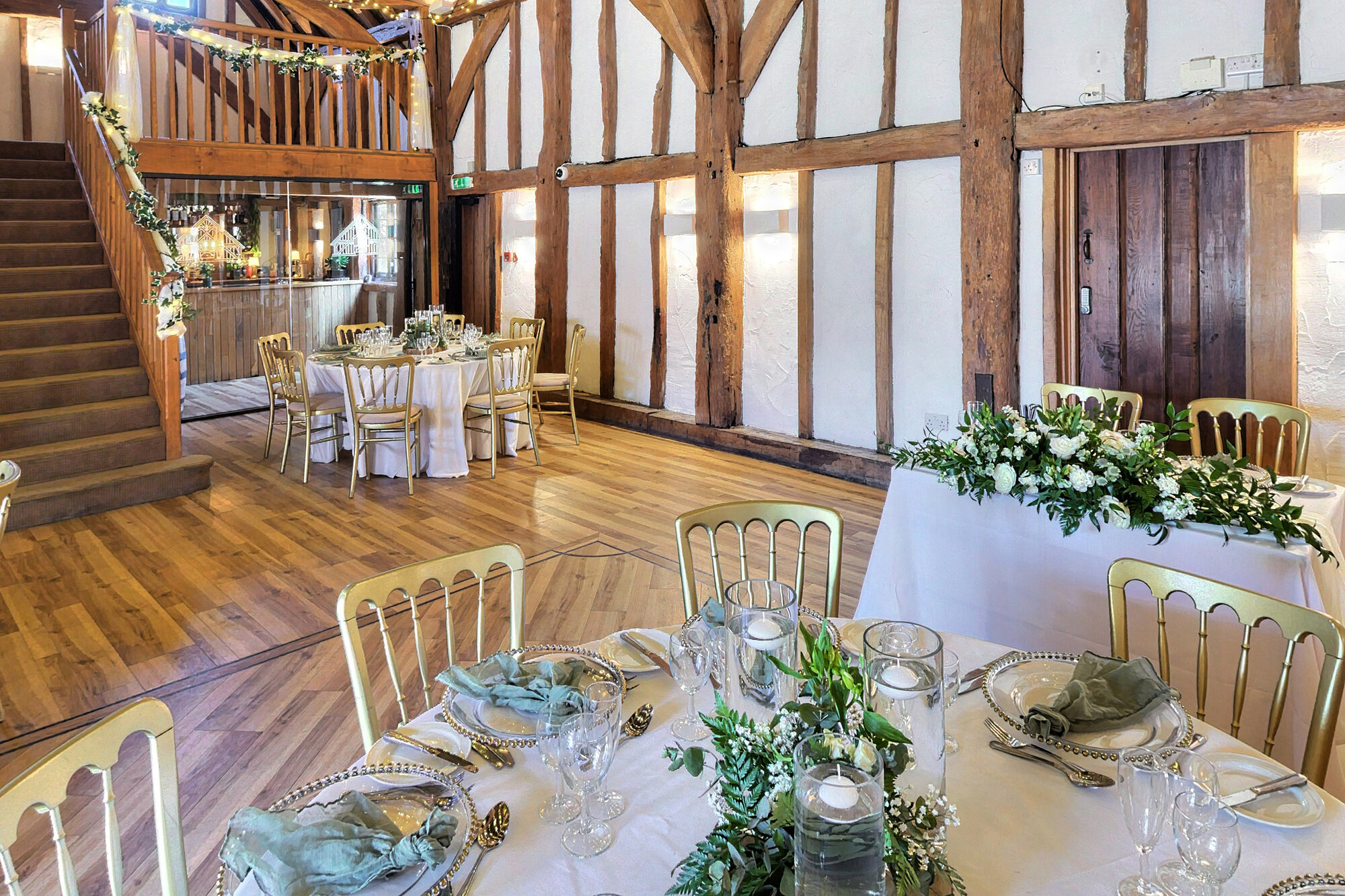 A close view of a dressed wedding table setting with glassware, foliage and place settings